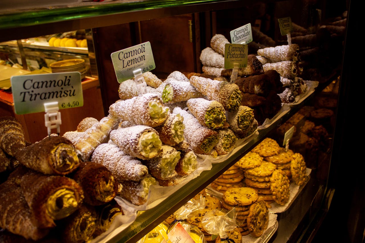 heros-img Mouthwatering assortment of Italian cannoli and pastries on display in a bakery. Perfect for food lovers.